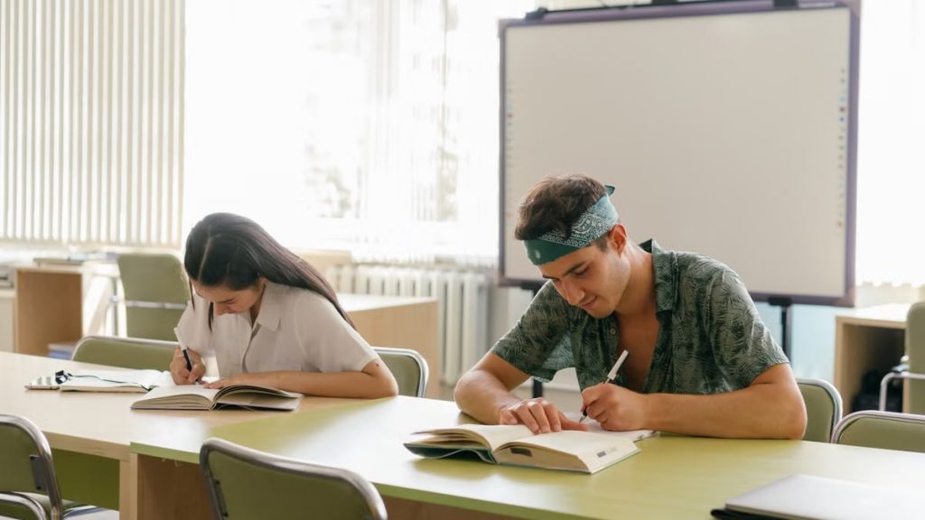 Two students focused on study in a bright, modern classroom.